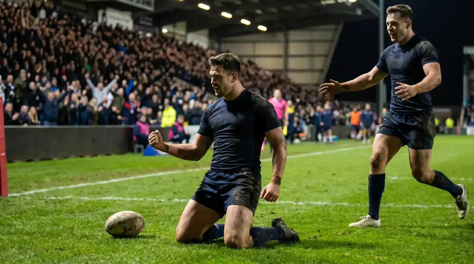 Rugby league player celebrating after scoring a try in the in-goal area