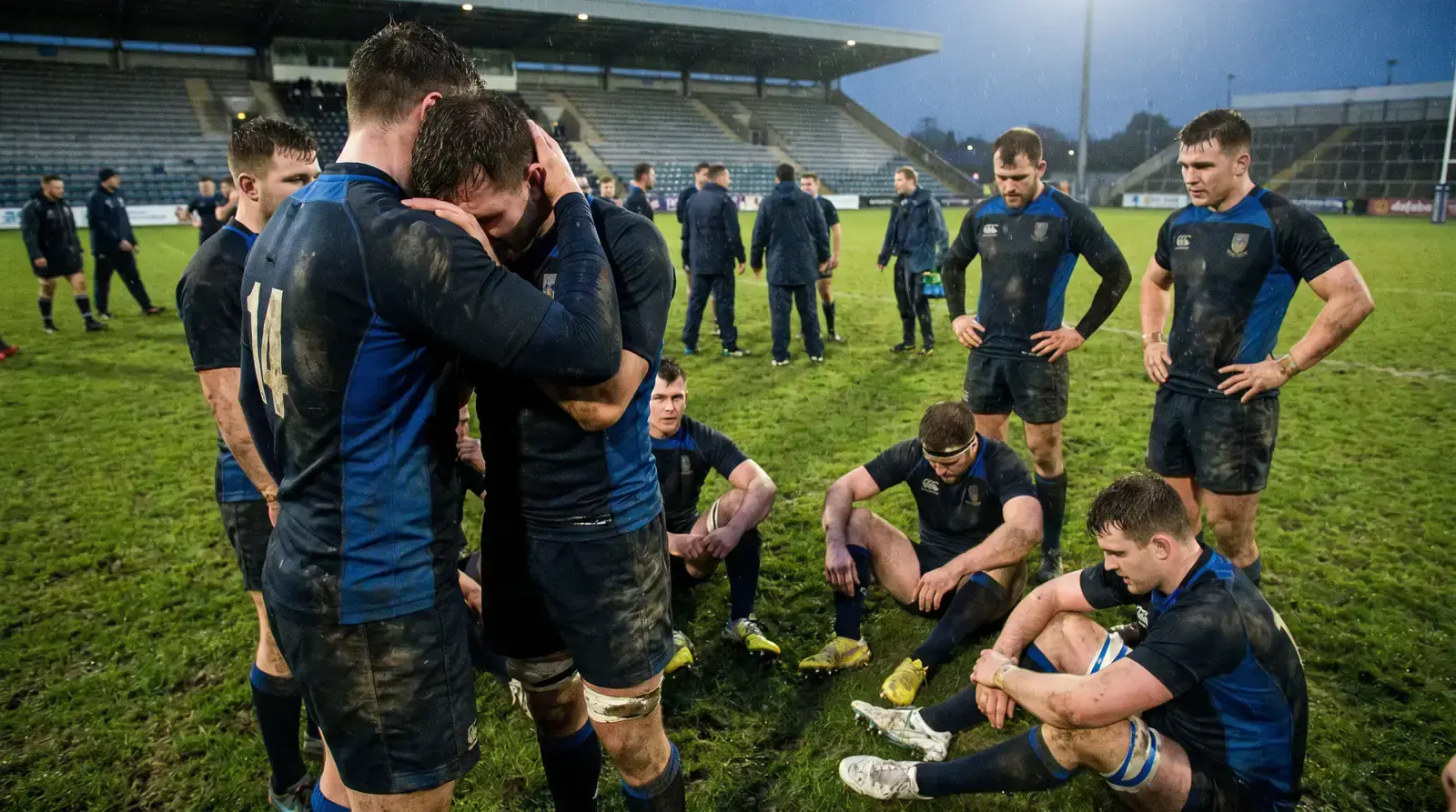 Rugby players consoling each other after a narrow defeat